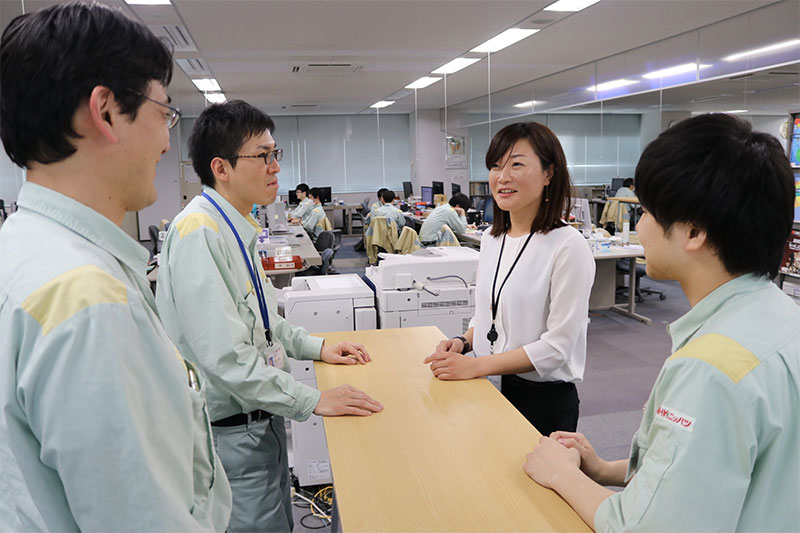 研究開発本部開発部主査M.I.さんが社員たちと会話している様子